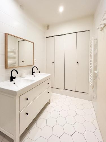 une salle de bain blanche avec un lavabo et un miroir dans l'établissement Jeu De Paume, à Montpellier