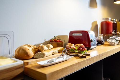 a table with bread and a toaster and a plate of food at La Villa - Luxury Guest House in Trento