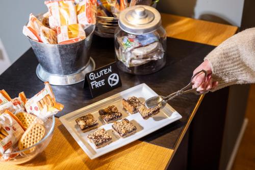a person is serving food on a table at La Villa - Luxury Guest House in Trento