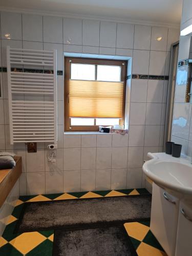 a bathroom with a sink and a window at Apartment Haus Klingspitz Pilzegg in Embach