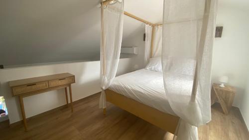 een slaapkamer met een hemelbed en een houten tafel bij A casa di Leia in Borgo