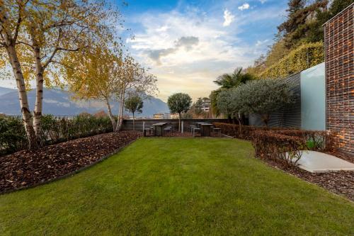 a backyard with a lawn and a brick building at La Villa - Luxury Guest House in Trento