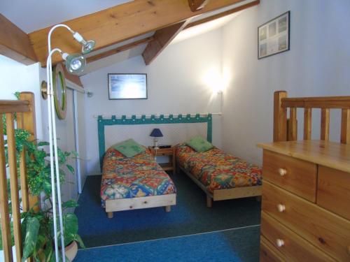 - une chambre avec 2 lits jumeaux et un escalier dans l'établissement Le Mas de Vertmarines, à Saint-Jean-de-Monts