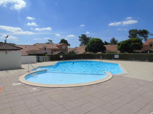 une grande piscine bleue dans une cour dans l'établissement Le Mas de Vertmarines, à Saint-Jean-de-Monts
