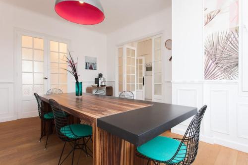 une cuisine avec une grande table et des chaises en bois dans l'établissement Palais area 4 beds - 4 baths, à Cannes