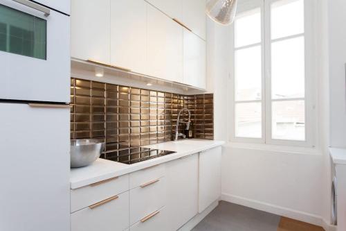 une cuisine avec des armoires blanches et un évier dans l'établissement Palais area 4 beds - 4 baths, à Cannes