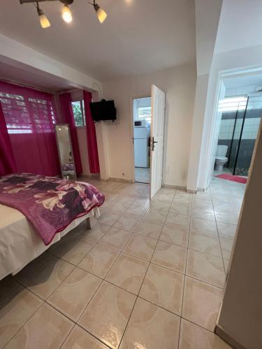 a bedroom with a bed and a tiled floor at Location tropical in Sainte-Anne
