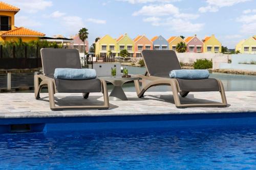 two chairs and a table next to a swimming pool at Casa Blue Marlin in Kralendijk