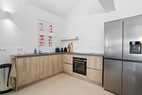 a kitchen with wooden cabinets and a stainless steel refrigerator at Casa Blue Marlin in Kralendijk