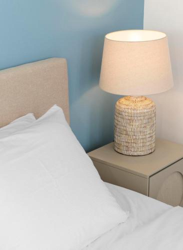 a white bed with a lamp on a side table at Casa Blue Marlin in Kralendijk
