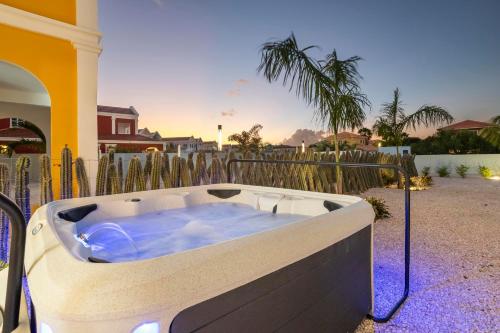 a hot tub sitting in a yard next to a fence at Casa Blue Marlin in Kralendijk
