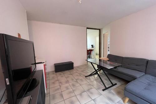 een woonkamer met een bank en een tafel bij Le Baheux Urbain in Le Havre