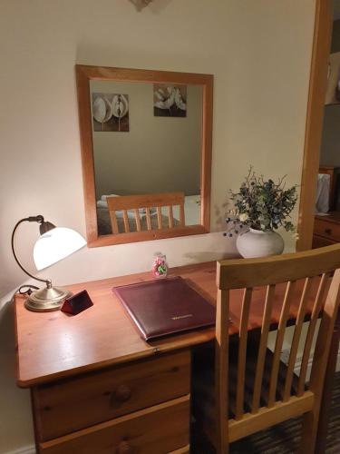 a desk with a mirror and a lamp on it at Apple Blossom Guesthouse in Rempstone