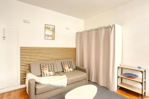 ein Wohnzimmer mit Sofa und Tisch in der Unterkunft Le Chat Botté - Versailles in Versailles