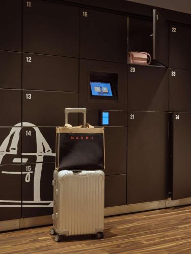 a suitcase sitting in a room with a wall at Flemings Hotel Frankfurt Main-Riverside in Frankfurt/Main