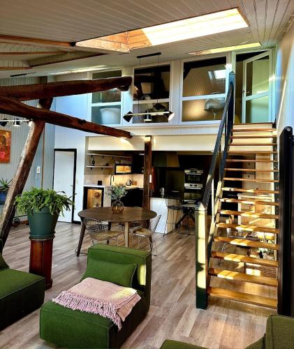 un salon avec un escalier et une table dans l'établissement ღ Merciers Duplex de charme au centre historique, à La Rochelle