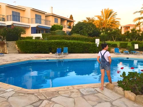 a woman standing in front of a swimming pool at Paradise Gardens Cozy Oasis with AC, WIFI, and pool in Paphos City