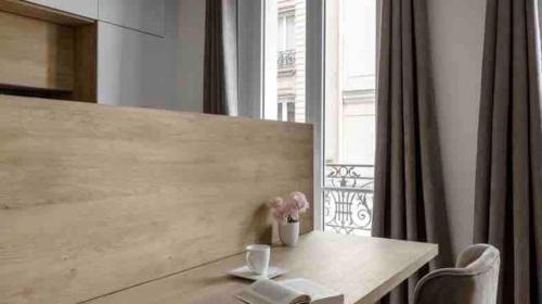 une table avec des fleurs à côté d'une fenêtre dans l'établissement Paris Cozy Apartment 15th Dist- EIFFEL TOUR, à Paris