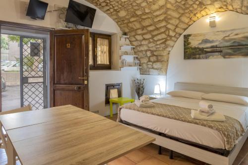 ein Schlafzimmer mit einem Bett und einem Holztisch in der Unterkunft La casetta di Pietra in Sassari