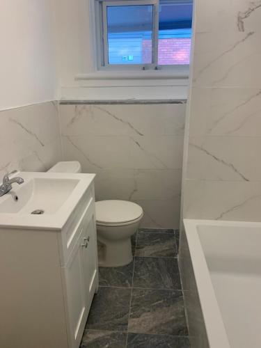 a white bathroom with a toilet and a sink at Only Private Room Steps To University Of Ottawa Downtown Not Full apt in Ottawa