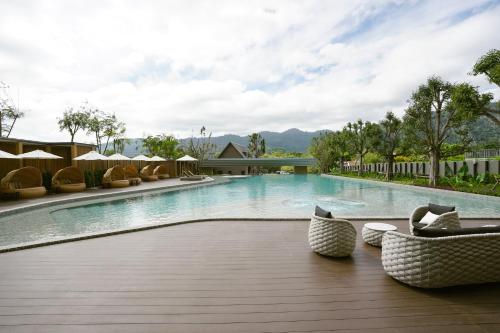 a large swimming pool with chairs and umbrellas at Viewpoint Khaoyai Hotel in Mu Si