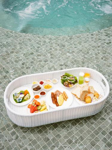 a tray of food on a table next to a swimming pool at Viewpoint Khaoyai Hotel in Mu Si