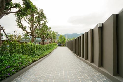 a walkway leading down a road with a fence at Viewpoint Khaoyai Hotel in Mu Si
