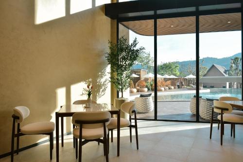 a dining room with a table and chairs and a pool at Viewpoint Khaoyai Hotel in Mu Si
