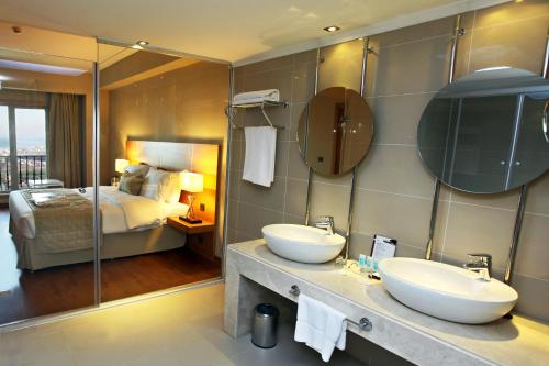 a hotel bathroom with two sinks and a bed at Anemon Kent İskenderun Otel in İskenderun
