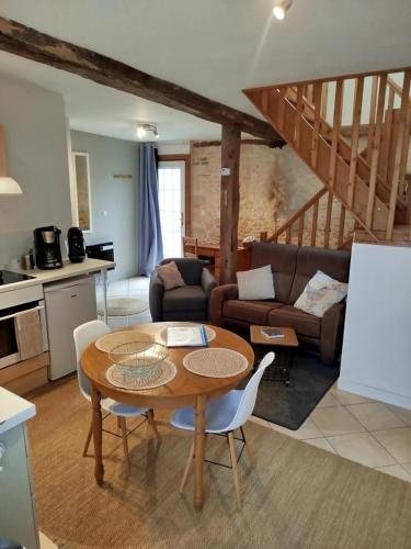 a living room with a table and a couch at La Ferme de Frévan in Sarceaux