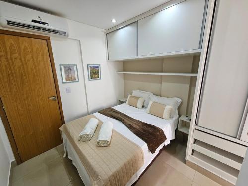 a small bedroom with a bed with towels on it at Lindissimo Flat 101 a uma esquina Flamboyant Shop in Goiânia