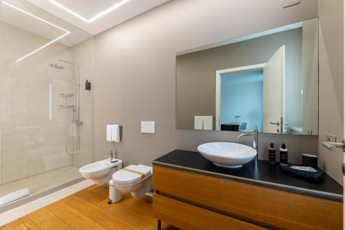 a bathroom with a sink and a toilet and a mirror at La Villa - Luxury Guest House in Trento