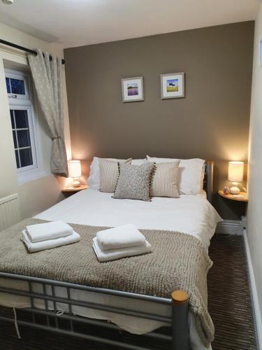 a bedroom with a bed with two towels on it at Apple Blossom Guesthouse in Rempstone