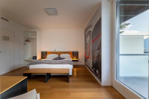 a bedroom with a bed and a large window at La Villa - Luxury Guest House in Trento