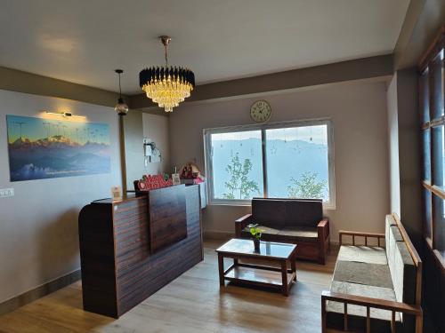 a living room with a couch and a table at Lamahatta Clouds Hotel & Restaurant in Takdāh