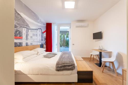 a bedroom with a bed and a desk and a table at La Villa - Luxury Guest House in Trento