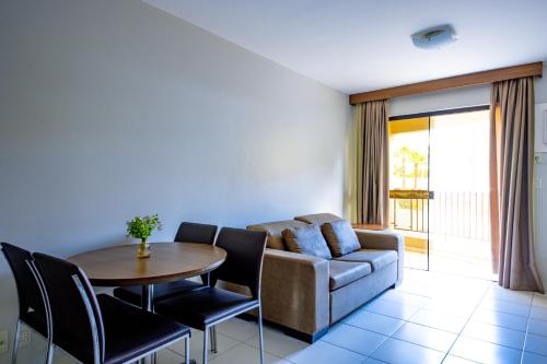 a living room with a couch and a table and chairs at Boulevard Suíte Hotel by WAM Experience in Caldas Novas