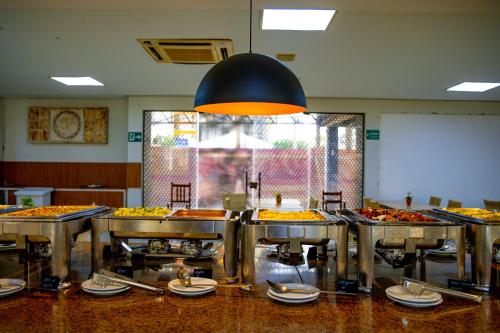 a restaurant with many trays of food on display at Boulevard Suíte Hotel by WAM Experience in Caldas Novas