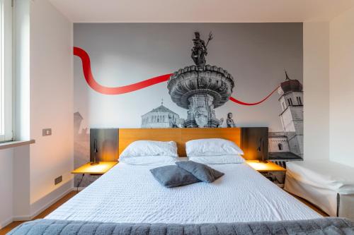 a bedroom with a large white bed with a mural on the wall at La Villa - Luxury Guest House in Trento