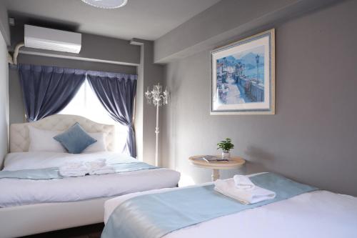 a hotel room with two beds and a window at Spacious 80sqm Apt near Shibuya Crossing, 8 min walk to Shibuya Station in Tokyo