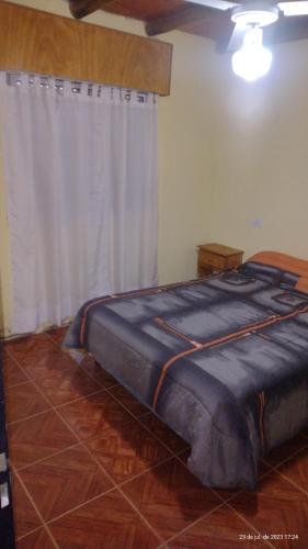 a large bed in a room with a white curtain at Duplex Brisas del Mar 2A in Barrio Félix U Camet