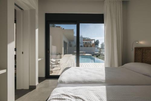 a bedroom with a bed and a view of a pool at VILLA ARMONIA 3 bed family villa with private pool in Paleros
