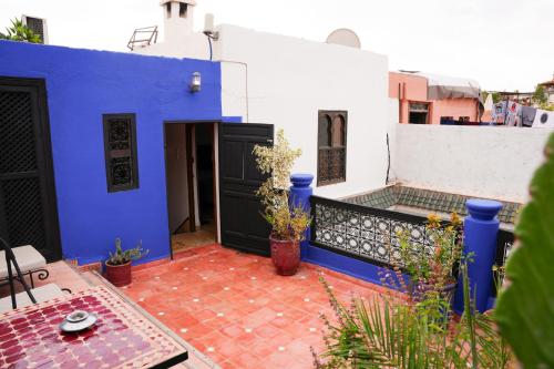 a blue and white house with a patio with plants at Archduke private rooms in Marrakech