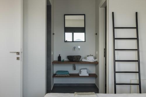 a bathroom with a sink and a mirror on the wall at VILLA ARMONIA 3 bed family villa with private pool in Paleros