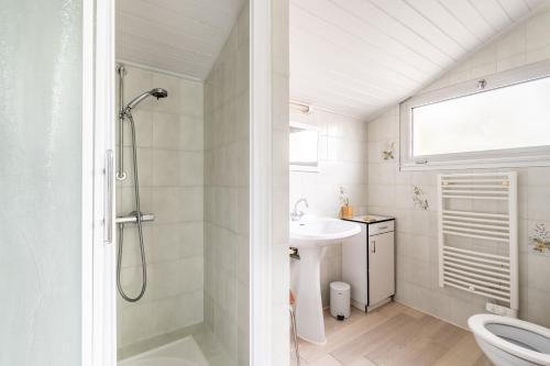 une salle de bain blanche avec une douche et un lavabo dans l'établissement 128-Aux beaux volumes, proche plage, à Pornic