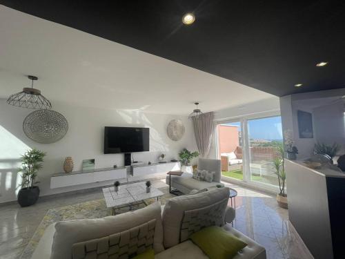 un salon avec un canapé et une télévision dans l'établissement Magnifique appartement à 2 pas de la plage..., à Calvi