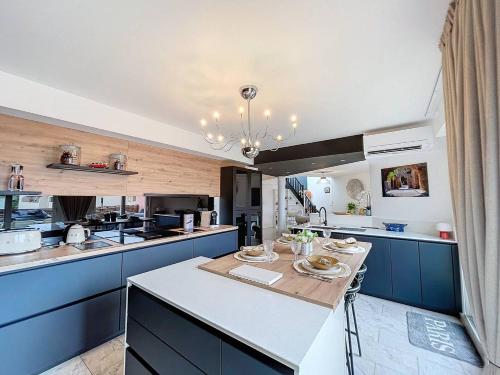une grande cuisine avec des placards bleus et une table dans l'établissement Magnifique appartement à 2 pas de la plage..., à Calvi