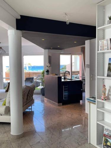 - une cuisine et un salon avec une table et un comptoir dans l'établissement Magnifique appartement à 2 pas de la plage..., à Calvi