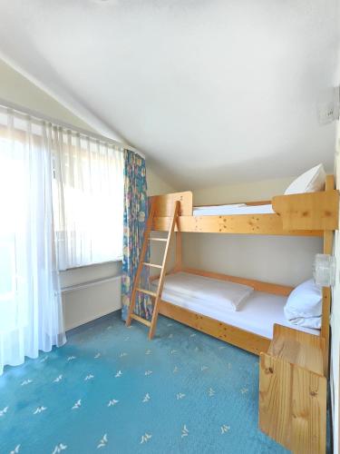 a bedroom with two bunk beds and a window at Holzschuhs Schwarzwaldhotel in Baiersbronn