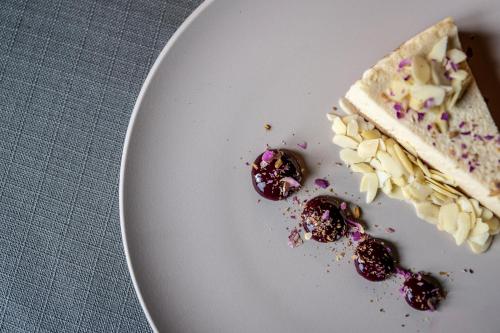 a piece of cake on a white plate with cherries at Swissôtel Resort Kolasin in Kolašin
